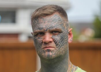 Un hombre con extensos tatuajes de cara.