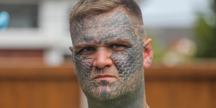 Un hombre con extensos tatuajes de cara.