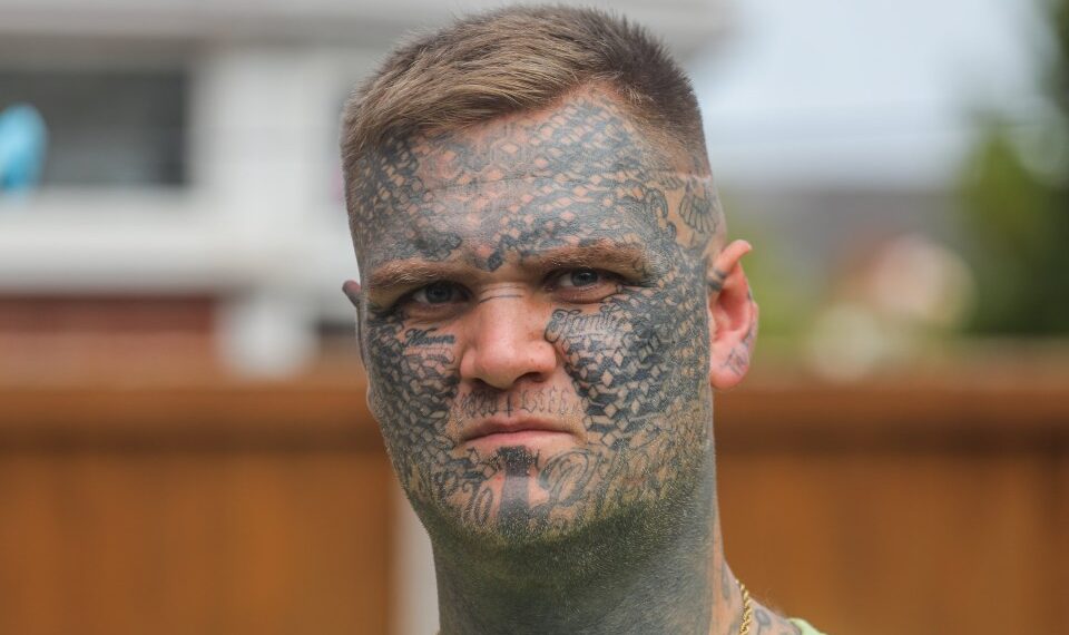 Un hombre con extensos tatuajes de cara.