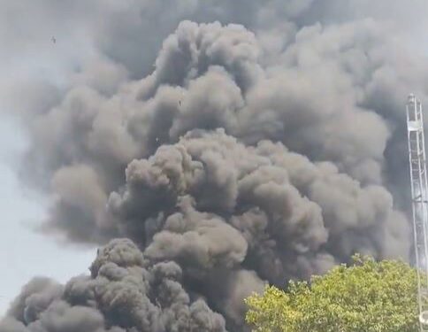 Gran columna de humo negro que ondula sobre los edificios.