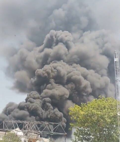 Gran columna de humo negro que ondula sobre los edificios.