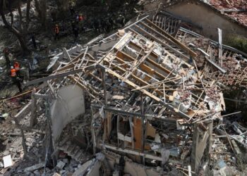 Personal de emergencia en un edificio destruido después de una huelga de misiles.