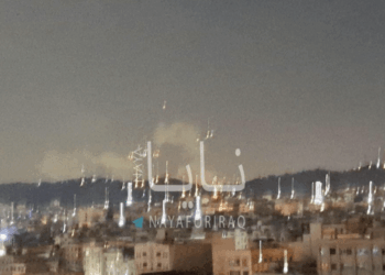 Vista nocturna de una ciudad con fuegos artificiales.