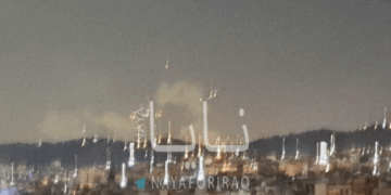 Vista nocturna de una ciudad con fuegos artificiales.