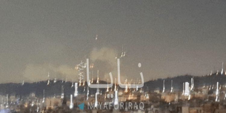 Vista nocturna de una ciudad con fuegos artificiales.