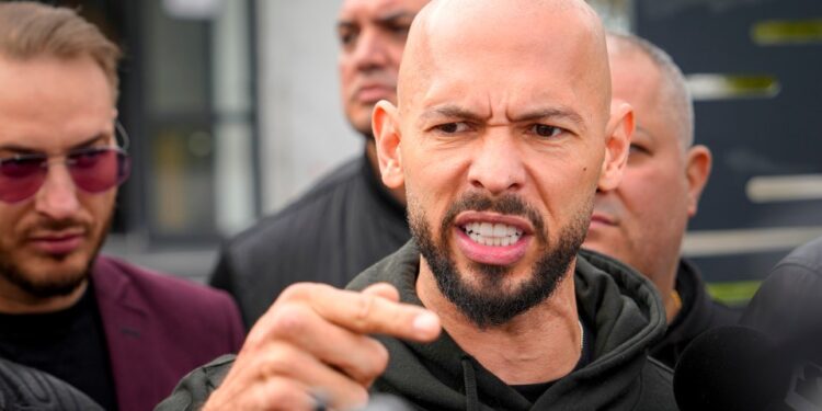Andrew Tate hablando con los medios de comunicación fuera de una estación de policía.