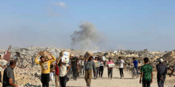 Los palestinos desplazados reciben paquetes de alimentos de una fundación respaldada por Estados Unidos que se comprometen a distribuir ayuda humanitaria, en el oeste de Rafah en la Franja del Sur de Gaza, el 27 de mayo de 2025.