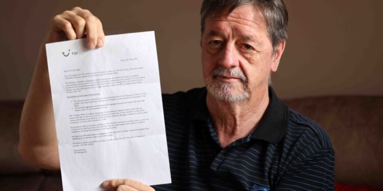 Hombre sosteniendo una carta explicando la cancelación de vacaciones de tui.