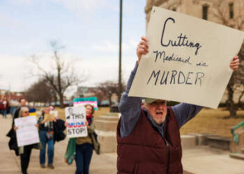 Un manifestante posee un letrero que lee 'Cortar Medicaid es asesinato' durante una manifestación contra el presidente Donald Trump, Elon Musk y la administración Trump fuera de la casa estatal en Indianápolis, Indiana, el 4 de marzo de 2025.