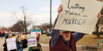 Un manifestante posee un letrero que lee 'Cortar Medicaid es asesinato' durante una manifestación contra el presidente Donald Trump, Elon Musk y la administración Trump fuera de la casa estatal en Indianápolis, Indiana, el 4 de marzo de 2025.