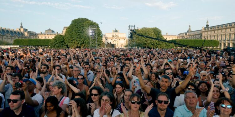 Las personas aplauden mientras se reúnen para escuchar música antes de la reinstalación y el despegue del caldero olímpico de 2024 durante un concierto gratuito para el festival anual de música callejera de Mark France, 'Fete de la Musique', en el Jardin des Tuileries, en París el 21 de junio de 2025. (Foto de Geoffroy Van der Hasselt / Afp) (Foto de Geoffroy Van Deren Herhroy / Afpting.