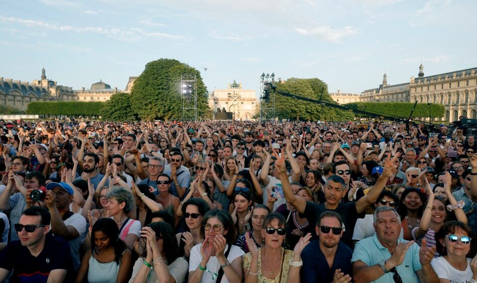 Las personas aplauden mientras se reúnen para escuchar música antes de la reinstalación y el despegue del caldero olímpico de 2024 durante un concierto gratuito para el festival anual de música callejera de Mark France, 'Fete de la Musique', en el Jardin des Tuileries, en París el 21 de junio de 2025. (Foto de Geoffroy Van der Hasselt / Afp) (Foto de Geoffroy Van Deren Herhroy / Afpting.