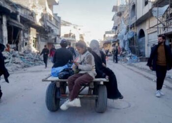 Una niña revisa su teléfono inteligente en la parte trasera de un carro como en el norte de Gaza, el 28 de febrero de 2025.