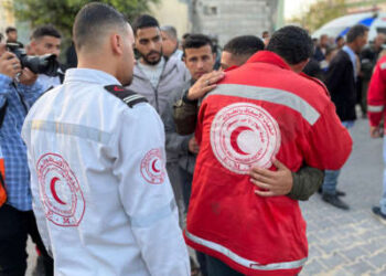 Un paramédico abraza a una juventud como los cuerpos de los socorristas palestinos, que fueron asesinados una semana antes en el incendio militar israelí sobre ambulancias, llegan al complejo médico de Nasser en Khan Yunis en la Franja del Sur de Gaza el 30 de marzo de 2025.
