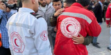 Un paramédico abraza a una juventud como los cuerpos de los socorristas palestinos, que fueron asesinados una semana antes en el incendio militar israelí sobre ambulancias, llegan al complejo médico de Nasser en Khan Yunis en la Franja del Sur de Gaza el 30 de marzo de 2025.