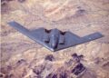 B-2 Bombardero de sigilo espiritual en vuelo sobre el terreno del desierto.
