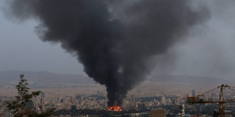 Humo que se eleva de un edificio en llamas en Teherán, luego de una huelga israelí.