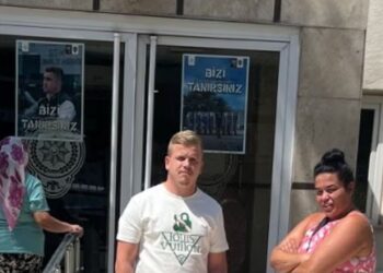 Pareja parada frente a una estación de policía.