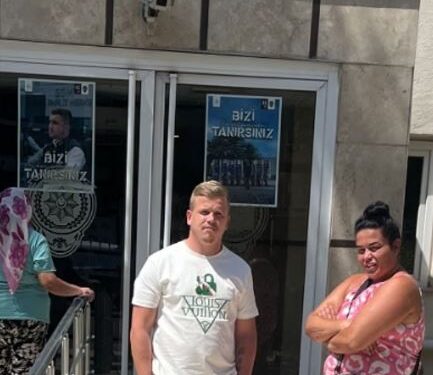 Pareja parada frente a una estación de policía.