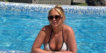 Mujer en un bikini blanco relajándose en una piscina.