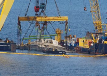 Crane barcos levantando un yate hundido.