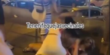 Dos mujeres peleando en el suelo por la noche.