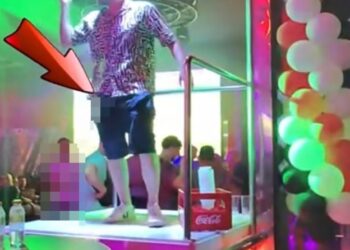 Un hombre que orina desde un podio de bar en Benidorm.