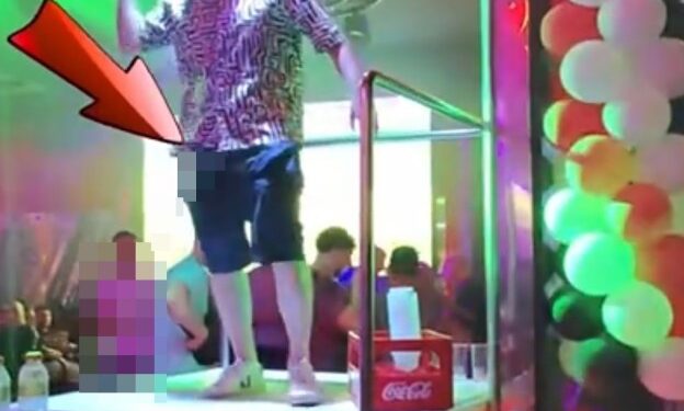 Un hombre que orina desde un podio de bar en Benidorm.