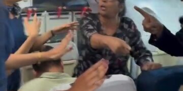 Un pasajero discutiendo con azafatas en un avión.