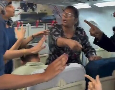 Un pasajero discutiendo con azafatas en un avión.