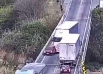 Las imágenes de CCTV de un automóvil son empujados de un paso elevado por un camión.