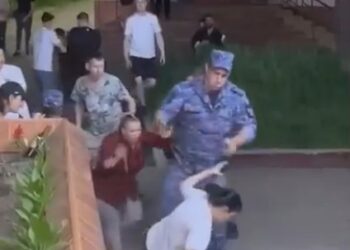 Un soldado apunta un arma en la cabeza de una mujer durante la pelea de un restaurante.