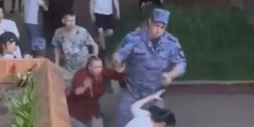 Un soldado apunta un arma en la cabeza de una mujer durante la pelea de un restaurante.