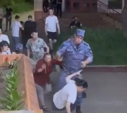 Un soldado apunta un arma en la cabeza de una mujer durante la pelea de un restaurante.