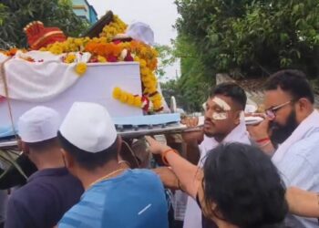 Un hombre que lleva el ataúd de su hermano en una procesión fúnebre.