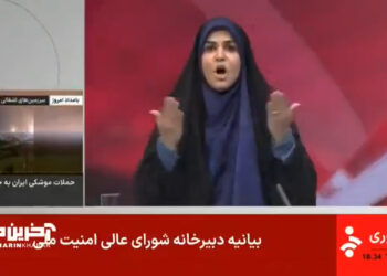 Captura de pantalla de un informe de noticias que muestra a una mujer en un hijab reaccionando ante las noticias de los ataques de misiles.