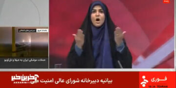 Captura de pantalla de un informe de noticias que muestra a una mujer en un hijab reaccionando ante las noticias de los ataques de misiles.
