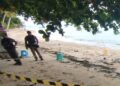 Escena del crimen en una playa con policías.