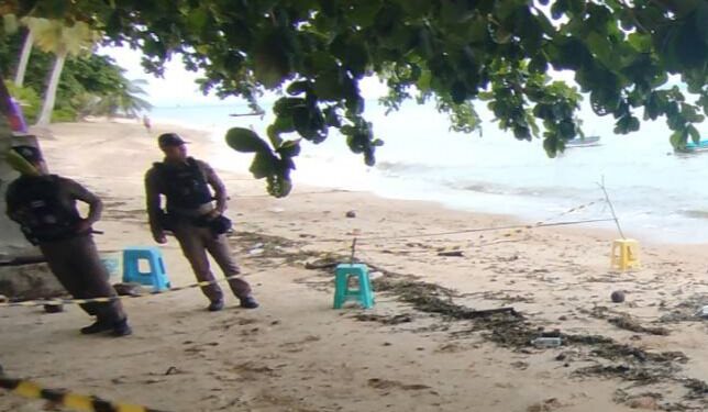 Escena del crimen en una playa con policías.