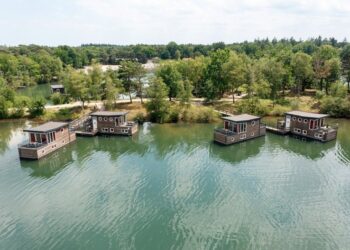 Vista aérea de cuatro casas flotantes en un lago.