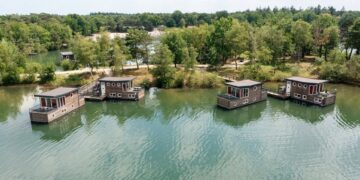 Vista aérea de cuatro casas flotantes en un lago.
