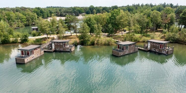 Vista aérea de cuatro casas flotantes en un lago.