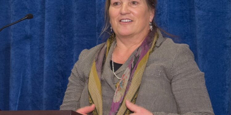 Foto de Joanna Miller hablando en un podio.