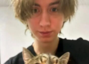 Foto de una persona joven sosteniendo un gato.