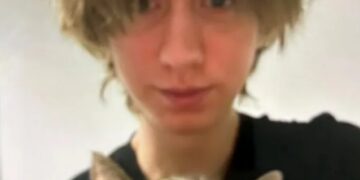 Foto de una persona joven sosteniendo un gato.