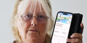 Mujer sosteniendo teléfono que muestra una reserva de hotel Tui.