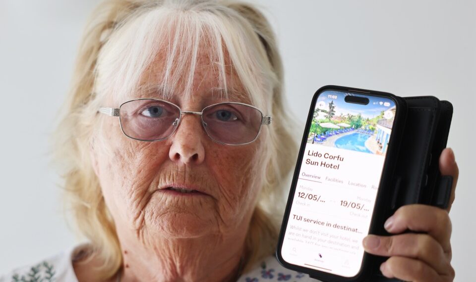 Mujer sosteniendo teléfono que muestra una reserva de hotel Tui.