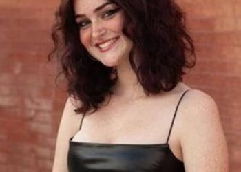 Retrato de una adolescente sonriente con un vestido negro.