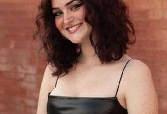 Retrato de una adolescente sonriente con un vestido negro.