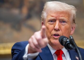 El presidente Donald Trump hablando en un podio.